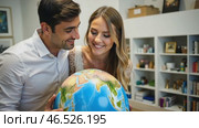 Man and a woman are looking at a globe. Стоковое AI-видео, аниматор Sergey Grishin / Фотобанк Лори