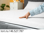 Женщина прикасается к мягкому ортопедическому матрасу на кровати дома, крупный план. Стоковое фото, фотограф Pixel_shot / Фотобанк Лори