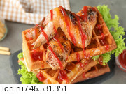 Вкусные вафли с куриными крылышками и соусом на грифельной тарелке, крупным планом. Стоковое фото, фотограф Pixel_shot / Фотобанк Лори