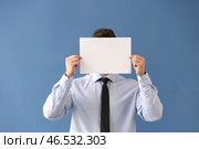 Бизнесмен, скрывая лицо за чистый лист бумаги на цветном фоне. Стоковое фото, фотограф Pixel_shot / Фотобанк Лори