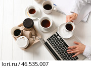 Бизнесмен с большим количеством пустых чашек кофе, работающих за столом. Концепция наркомании. Стоковое фото, фотограф Pixel_shot / Фотобанк Лори
