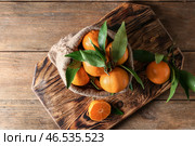 Мешочек с вкусными сочными мандаринами на деревянной доске. Стоковое фото, фотограф Pixel_shot / Фотобанк Лори
