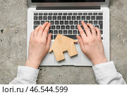 Агент по недвижимости с деревянным домом и ноутбуком на гранж-фоне. Стоковое фото, фотограф Pixel_shot / Фотобанк Лори
