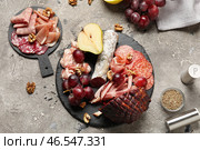 Шиферная тарелка и доска с ассортиментом вкусных мясных деликатесов на сером фоне. Стоковое фото, фотограф Pixel_shot / Фотобанк Лори