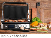 Современный электрический гриль с вкусными стейками и овощами на деревянном фоне. Стоковое фото, фотограф Pixel_shot / Фотобанк Лори