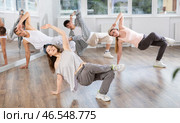 Girl and her students perform hip hop dance on one bent leg, movement in horizontal plane near floor. Стоковое фото, фотограф Яков Филимонов / Фотобанк Лори