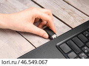Женщина использует черный USB-накопитель с современным ноутбуком на белом деревянном фоне. Стоковое фото, фотограф Pixel_shot / Фотобанк Лори