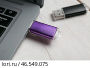 Ноутбук с флешкой на светлом деревянном фоне, крупным планом. Стоковое фото, фотограф Pixel_shot / Фотобанк Лори