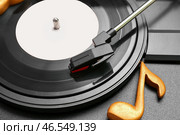 Проигрыватель с виниловым диском и нотной табличкой, крупным планом. Стоковое фото, фотограф Pixel_shot / Фотобанк Лори
