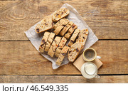 Вкусное печенье бискотти, чашка кофе и молоко в кувшине на деревянном фоне. Стоковое фото, фотограф Pixel_shot / Фотобанк Лори