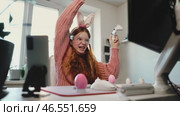 Overjoyed girl raises controller in triumph, celebrating gaming victory. Dressed in bunny ears and LED glasses, she embraces Easter festivity in tech-inspired, modern gaming space. Стоковое видео, видеограф Енваев Андрей / Фотобанк Лори