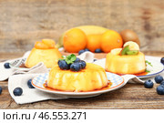 Тарелки вкусных пудингов с фруктами и черникой, покрытые карамельным сиропом, на деревянном столе. Стоковое фото, фотограф Pixel_shot / Фотобанк Лори