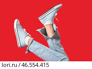 Женские ноги в стильных кедах на красном фоне, крупным планом. Стоковое фото, фотограф Pixel_shot / Фотобанк Лори