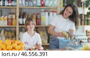 Portrait of capricious offended girl against background of dissatisfied mother - family quarrel in a grocery store. Стоковое видео, видеограф Яков Филимонов / Фотобанк Лори