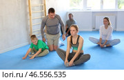 Big family before training martial arts performs stretching butterfly. Стоковое видео, видеограф Яков Филимонов / Фотобанк Лори