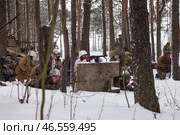 Sestroretsk, Russia - February 19, 2023: In a winter scene, soldiers plan for a key moment in WWII, surrounded by snow and trees in a historical reenactment. Редакционное фото, фотограф Aleksandr Golubev / Фотобанк Лори