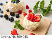 Вкусные пирожные Павлова со свежими ягодами на светлом фоне. Стоковое фото, фотограф Pixel_shot / Фотобанк Лори