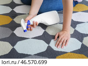 Женщина распыляет моющее средство на красочный ковер дома, крупным планом. Стоковое фото, фотограф Pixel_shot / Фотобанк Лори