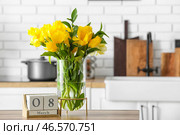 Ваза с тюльпанами и кубический календарь с датой 8 МАРТА на столе на кухне. Празднование Международного женского дня. Стоковое фото, фотограф Pixel_shot / Фотобанк Лори