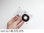 Прозрачная аудиокассета в руке на светлом фоне. Стоковое фото, фотограф Станислав Кноп / Фотобанк Лори