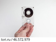 Прозрачная аудиокассета в руке на светлом фоне. Стоковое фото, фотограф Станислав Кноп / Фотобанк Лори