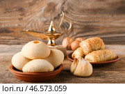 Вкусные восточные сладости с лампой Аладдина на деревянном фоне. Стоковое фото, фотограф Pixel_shot / Фотобанк Лори