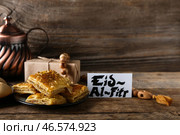 Вкусная турецкая пахлава с подарком и поздравительной открыткой на Ид аль-Фитр (Праздник разговения) на деревянном фоне. Стоковое фото, фотограф Pixel_shot / Фотобанк Лори