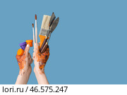 Женские руки с кисточками, гуашью и мастихинами на голубом фоне. Стоковое фото, фотограф Pixel_shot / Фотобанк Лори