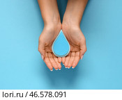 Женские руки с каплями бумаги на голубом фоне. Всемирный день полиомиелита. Стоковое фото, фотограф Pixel_shot / Фотобанк Лори