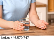 Женщина держит стакан воды и шипучую таблетку на деревянном столе. Стоковое фото, фотограф Pixel_shot / Фотобанк Лори