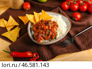 Чаша с вкусным чили кон карне, рисом, начос и овощами на деревянном фоне. Стоковое фото, фотограф Pixel_shot / Фотобанк Лори