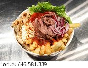 Картофель фри, красный лук, мясо, листья салата, помидоры и нарезанная лепешка, поданные с соусами. Стоковое фото, фотограф Артем Геодакян / ТАСС / Фотобанк Лори