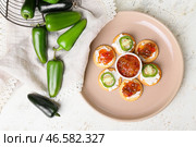 Вкусные крекеры с творогом и вареньем из перца халапеньо в тарелке на светлом фоне. Стоковое фото, фотограф Pixel_shot / Фотобанк Лори