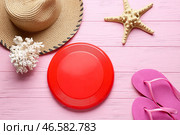 Диск фрисби, шляпа, коралл, шлепанцы и морская звезда на цветном деревянном фоне. Стоковое фото, фотограф Pixel_shot / Фотобанк Лори