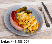 Fried small sausage and french fries, completed with pickled gherkin cucumber. Стоковое фото, фотограф Яков Филимонов / Фотобанк Лори