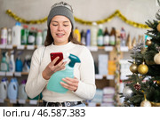 Female client scanning QR code on package tile cleaner spray. Стоковое фото, фотограф Яков Филимонов / Фотобанк Лори