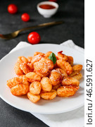Вкусные клецки с томатным соусом в тарелке на темном столе, крупным планом. Стоковое фото, фотограф Pixel_shot / Фотобанк Лори