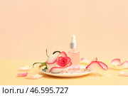 Бутылка косметического масла с экстрактом розы и цветком на бежевом столе. Стоковое фото, фотограф Pixel_shot / Фотобанк Лори