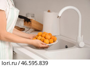 Молодая женщина собирается помыть абрикосы на кухне. Крупный план. Стоковое фото, фотограф Pixel_shot / Фотобанк Лори