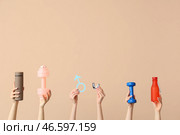 Женские руки с бутылками воды, гантелями и мужским знаком на бежевом фоне. Концепция рака простаты. Стоковое фото, фотограф Pixel_shot / Фотобанк Лори