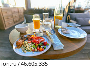 Delicious appetizing seafood breakfast with orange juice on the open veranda of the restaurant. Стоковое фото, фотограф Евгений Ткачёв / Фотобанк Лори
