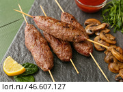 Доска шашлыков с вкусным люля-кебабом на столе, крупным планом. Стоковое фото, фотограф Pixel_shot / Фотобанк Лори