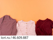 Clothes of baby girl on orange background top view. Стоковое фото, фотограф Сергей Толмачёв / Фотобанк Лори