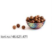 Macadamia nuts in bowl on white background, copy space. Стоковое фото, фотограф Зарифа Арсланова / Фотобанк Лори