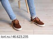 Ноги мужчины в коричневых туфлях с развязанными шнурками дома. Стоковое фото, фотограф Pixel_shot / Фотобанк Лори
