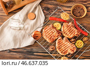 Стеллаж с вареными свиными стейками и овощами на столе. Стоковое фото, фотограф Pixel_shot / Фотобанк Лори