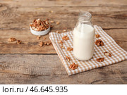 Бутылка вкусного грецкого ореха на столе. Стоковое фото, фотограф Pixel_shot / Фотобанк Лори