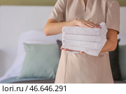 Домработница с чистыми полотенцами в спальне. Стоковое фото, фотограф Pixel_shot / Фотобанк Лори