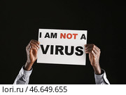 Афро-американский мужчина с плакатом на темном фоне. Остановить расизм. Стоковое фото, фотограф Pixel_shot / Фотобанк Лори
