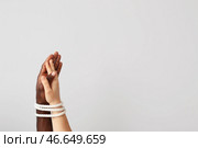 Руки кавказской женщины и афро-американского мужчины связаны веревкой на светлом фоне. Концепция расизма. Стоковое фото, фотограф Pixel_shot / Фотобанк Лори